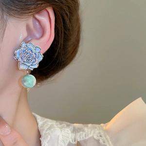 Detail of French vintage rose earrings with blue enamel flower and green marble bead
