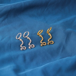 Snake drop earrings in gold and silver finish with pavé zircon stones on blue silk