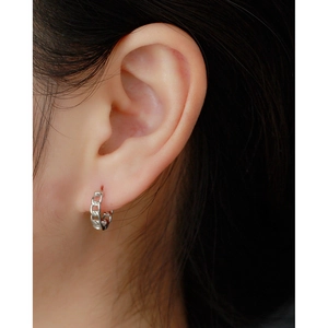 Close-up of a silver chain hoop earring worn by a model with a minimalist design