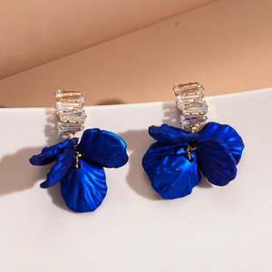 Détails des pétales de fleurs en acrylique et cristaux rectangulaires sur boucles dorées