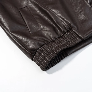 Détail de l'ourlet élastique et de la poche cousue sur cette veste en cuir marron