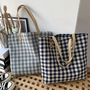 Detailansicht der hellblauen und marineblauen Gitter-Canvas-Taschen mit Ledergriffen