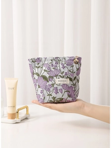 Floral embroidered makeup bag with lavender flowers and a golden flower zipper puller