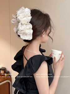Detail of white organza multi-layer bow hair claw clip showing volume and texture on hair