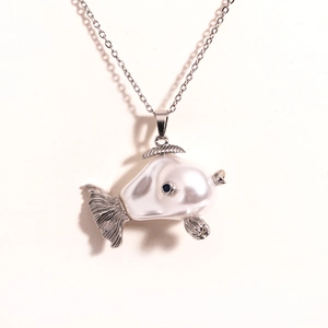 Detailed shot of fish pendant with white faux pearl body and blue gemstone eye detail