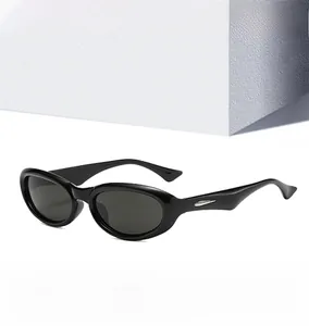 Detail view of oval black sunglasses featuring silver wing-shaped metal temple decoration