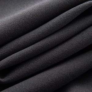 Macro texture of dark grey chiffon fabric showing detailed weave and soft draping effect