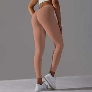 Détail du legging de yoga taille haute rose chair avec design froissé push-up fessier