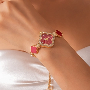 Detail of red clover-shaped wristwatch with crystal inlay on a woman's wrist