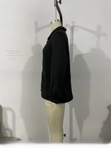 Detail of classic black long-sleeve jacket showing turn-down collar and cuffed sleeve