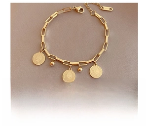 Vista macro de pulsera de cadena de acero de titanio dorado con monedas y abalorios