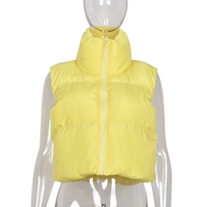 Detail view of yellow quilted vest featuring a protective stand collar and front zipper