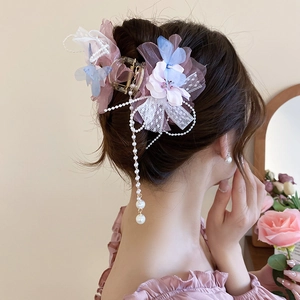 Detail der Organza-Blumen-Haarklammer mit eleganten Perlenquasten und rosa Spitze