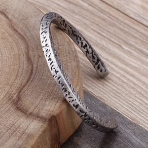 Macro detail of retro C-shaped titanium steel bracelet with oxidized etched texture