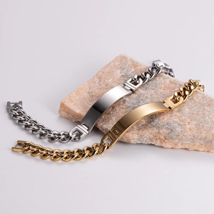 Frosted gold and silver Cuban ID bracelets displayed on stone props with polished plates