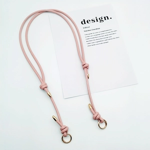 Detailed view of pink faux leather adjustable strap with gold buckles and knot design