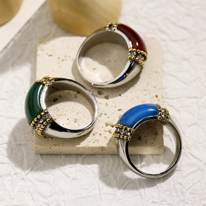 Three titanium steel rings with cat eye stone and crystal inlay on a stone pedestal
