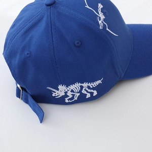 Close-up of navy cotton baseball cap with white triceratops skeleton embroidery and strap