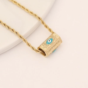 Detailed macro of gold Evil Eye pendant with Confiance engraving and twist chain