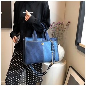 Detail of blue denim patchwork tote bag with gold swivel lock and adjustable strap