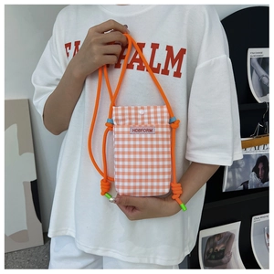 Detail showing orange and white checkered phone crossbody bag with bright orange rope strap