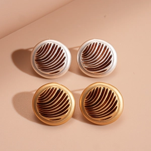 Vintage geometric round gold and silver stud earrings with ripple texture on beige background