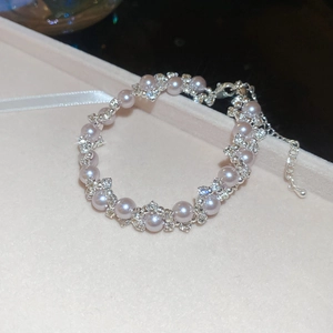 Macro detail of elegant pearl and rhinestone bracelet with silver adjustable lobster clasp