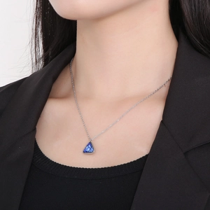 Detail of a minimalist titanium steel necklace featuring a blue triangle crystal pendant