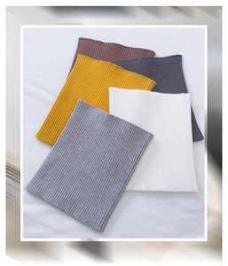 Flat lay of colorful knitted cashmere neck warmers with ribbed texture in multiple colors
