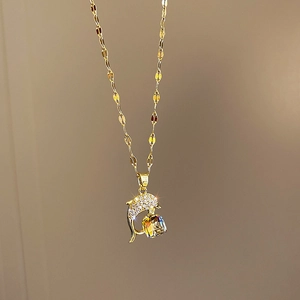 Detail of dolphin pendant with sparkling crystal and cubic zircon in titanium steel