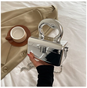 Detail of silver acrylic box bag with metallic mirror finish and unique top handle