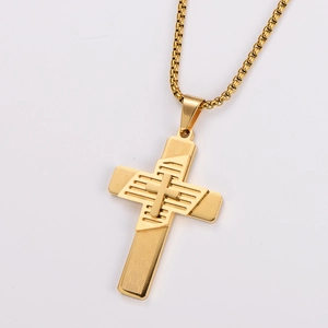 Detail of layered gold cross pendant with textured surface on a box chain