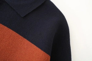 Detail of navy and orange striped polo collar with fine knit fabric texture