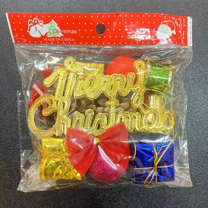 Close-up of Christmas tree decorations including gold Merry Christmas sign and gift boxes