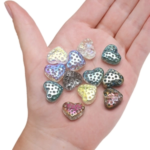 Colorful 13x15mm heart-shaped glass pendants held in hand to show size and glossy finish