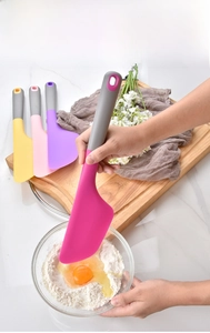 Silicone spatula mixing flour and eggs in a cozy kitchen baking scene
