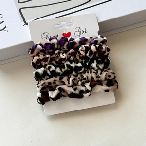 Close-up of a 5-piece velvet leopard print scrunchie set on a Sweet Girl display card