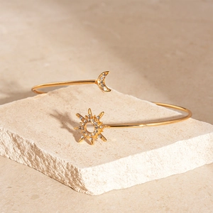 Elegant gold-tone sun and moon open cuff bracelet with cubic zirconia on stone base