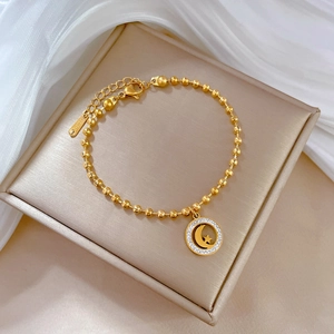 Titanium steel gold beaded bracelet with crystal moon and star pendant on satin