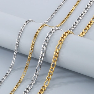 Detailed view of 4mm and 6mm gold and silver Figaro chains on a grey display stand