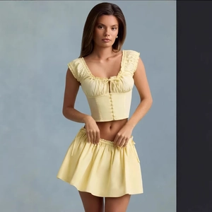 Chic two-piece floral set with yellow ruched crop top and matching mini skirt outfit