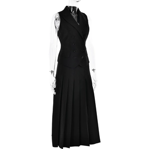 Détail d'un ensemble noir deux pièces avec gilet sans manches et jupe longue plissée