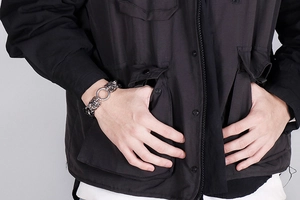 Detailed close-up of punk style skull head stainless steel leather bracelet for men