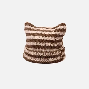 Close-up of thick brown and cream striped knit fabric with handmade crochet texture