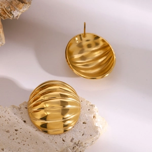 Polished gold textured chunky hoop earrings with oval ribbed design on a stone pedestal