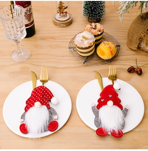 Gnome cutlery holder on a festive table setting with golden silverware and ceramics