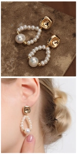 Detail of vintage gold pearl earrings with a large baroque pearl on a model and stone