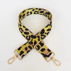 Close-up of leopard print nylon bag strap with adjustable gold metal buckle and hook