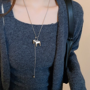 Silver Y-shaped necklace featuring a polished horse pendant shown on a model neck