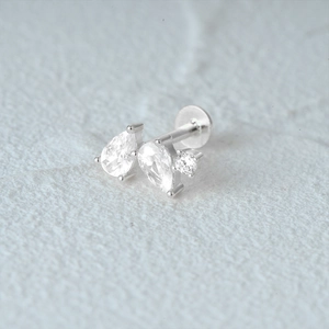 Macro shot of silver flat back cartilage stud with teardrop and round clear gemstones